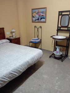 a bedroom with a bed and a chair and a table at Casa Rosa in Alcañiz +5 photos
