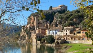 a town on the side of a mountain next to a river at Ebrevista in Miravet