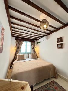 a bedroom with a large bed and a window at Riad Dar Home in Tétouan