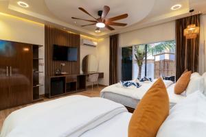 a bedroom with two beds and a flat screen tv at Hidden Tide Villa in Ukulhas