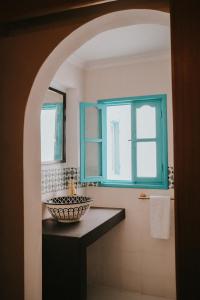 a bathroom with a sink and a blue window at Riad Dar Home in Tétouan +77 photos