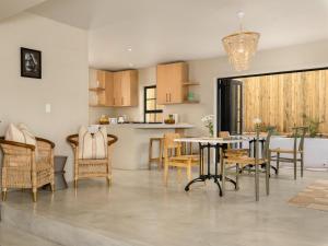 a kitchen and dining room with a table and chairs at Arc Guest House in Simonʼs Town +13 photos