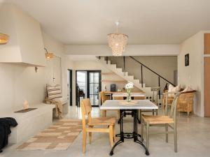 a kitchen and living room with a table and chairs at Arc Guest House in Simonʼs Town