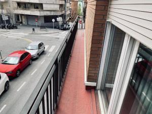 a red car parked on a street next to a building at Habitaciones Carmen in Rubí