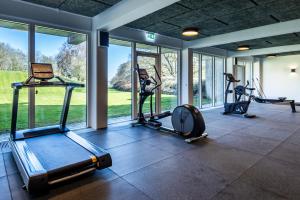 a gym with several treadmills and elliptical machines at KolleKolle Konferencehotel in Værløse