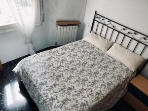 a bedroom with a bed with a black and white comforter at Habitaciones Carmen in Rubí