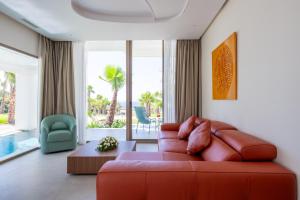 a living room with a red couch and a large window at Le Tanger Résidence Hôtelière in Tangier