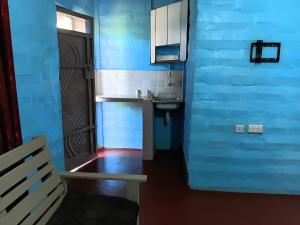 a blue room with a bench and a blue wall at Miale Guests Cottages in Kiamuringa