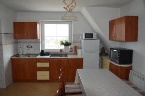 a kitchen with wooden cabinets and a white refrigerator at Mojone Izby in Maruszyna