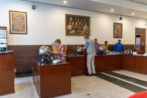 a man and a woman standing at a counter in a bar at Hotel Glitz Jaipur in Jaipur