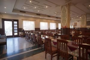 a dining room with tables and chairs in a restaurant at Hotel Glitz Jaipur in Jaipur