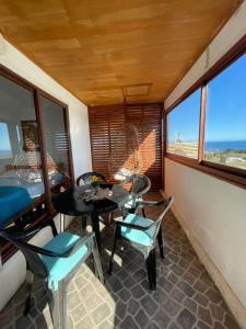 a room with a table and chairs and windows at Cabañas Bellavista del mar in De Cauquenes
