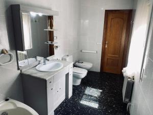 a white bathroom with a sink and a toilet at Habitaciones Carmen in Rubí +27 photos