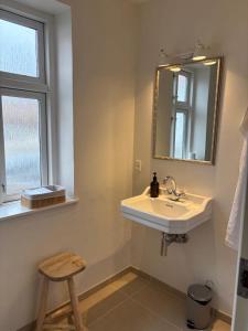 a bathroom with a sink and a mirror and a stool at Lund gamle skole - tæt på MCH in Herning