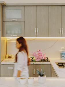 a woman walking in a kitchen at TITANIUM 9 Villa in Tlekung