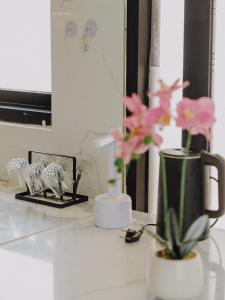 a counter with a vase with pink flowers on it at TITANIUM 9 Villa in Tlekung +31 photos