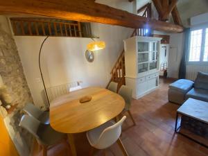 a wooden table and chairs in a living room at Cocon de l'écusson, 3 chambres avec clim in Nîmes +9 photos