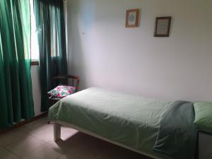 a bedroom with a bed and a chair next to a window at Flores del bosque in Ushuaia