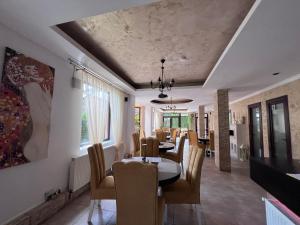 a dining room with a table and chairs at Pensiunea Silvian in Cheia