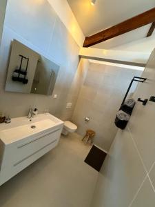 a white bathroom with a sink and a toilet at Bella Vita Hotel Restaurant in The Hague +16 photos