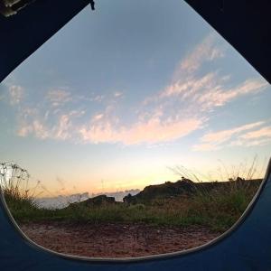 a view of the sunset through a window of a tent at EcoCamping da Wandinha in Cabo de Santo Agostinho +1 photo