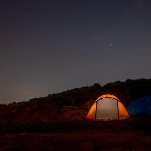an orange and white tent in a field at night at EcoCamping da Wandinha in Cabo de Santo Agostinho