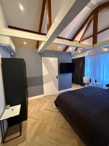 a bedroom with a large black bed and a tv at Bella Vita Hotel Restaurant in The Hague