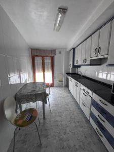 a kitchen with a table and chairs in a room at Casa Rosa in Alcañiz