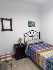 a bedroom with two beds and a mirror and a chair at Casa Rosa in Alcañiz