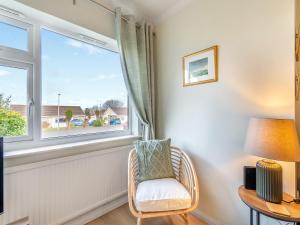 a living room with a chair and a window at Arosfa in St. Davids