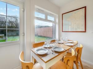 a dining room with a table and chairs and a window at Arosfa in St. Davids
