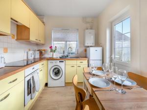 a kitchen with a table with wine glasses on it at Arosfa in St. Davids