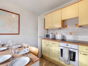 a kitchen with a wooden table with two white plates at Arosfa in St. Davids +14 photos