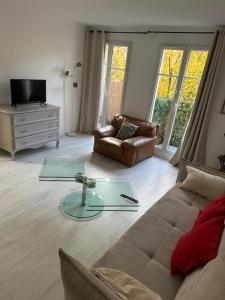 a living room with a couch and a glass table at Disney 4 min, from 4 to 14 Guests, 4 bedrooms, free parkings, 100 m2 in Chessy
