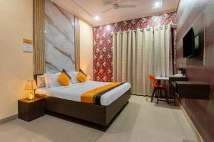 a hotel room with a bed and a desk and a television at Itsy Hotels Saina Stay Near 32 Milestone in Gurgaon +31 photos