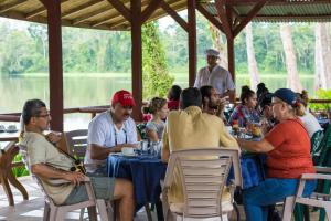 a group of people sitting at a table in a restaurant at Lirio Lodge in Barra de Pacuare