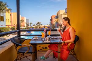 a woman sitting at a table with a drink at Al Dora Boutique Hotel in Hurghada