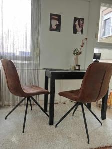 two chairs sitting next to a desk with a table at Studio apartman LUNA in Vinkovci