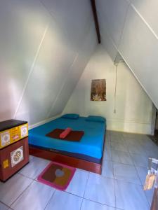 a small room with a bed and a table at Sumatra Thomas Leaf Monkey Guesthouse & Jungle Trek in Bukit Lawang