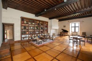 a large room with a library with tables and chairs at Château de Saint Maurice in La Peyrouse