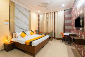 a hotel room with a bed and a desk at Itsy Hotels Saina Stay Near 32 Milestone in Gurgaon