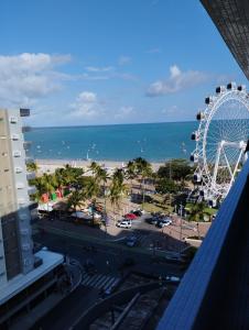 a view of the beach and a ferris wheel at Pajuçara Front Beach in Maceió