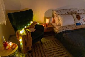 a bedroom with a bed and a chair with christmas lights at LM Apartman in Spišská Nová Ves