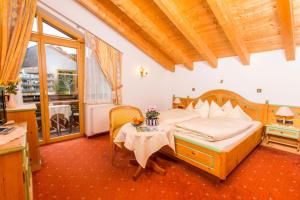 a bedroom with a bed and a table at Ferienwohnung Gästehaus Büchele Kleinwalsertal in Hirschegg