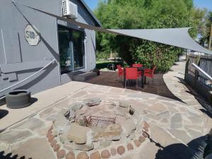 a patio with a fire pit and a table and chairs at The V8 House in Sutherland