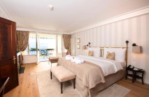 a bedroom with a large bed and a balcony at Hôtel Des Trois Couronnes & Spa - The Leading Hotels of the World in Vevey +110 photos