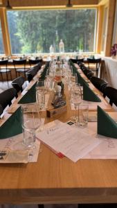 a long wooden table with wine glasses on it at Horská chata Libín in Prachatice