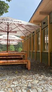 two benches with umbrellas in front of a building at Horská chata Libín in Prachatice