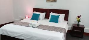 a bedroom with a large bed with blue and white pillows at bansri villa in Mount Lavinia