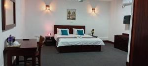 a bedroom with a bed with blue pillows and a desk at bansri villa in Mount Lavinia +18 photos